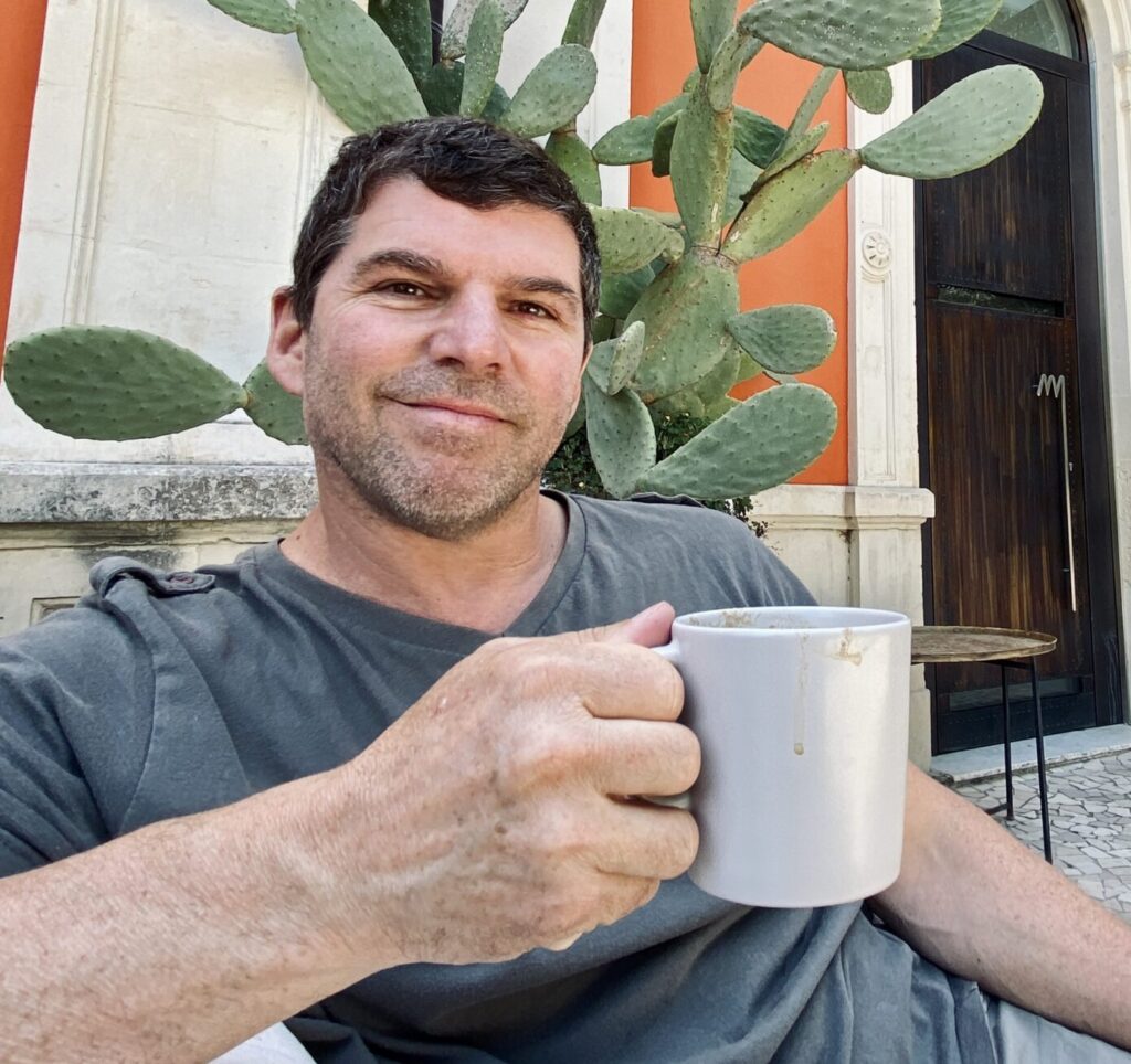Bruce in Italy holding a cup of coffee and relaxing